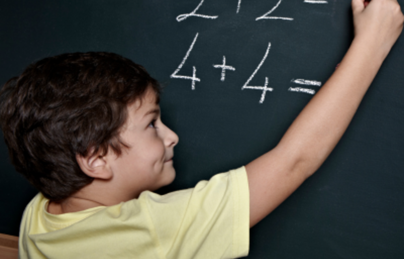 Child doing math on a board