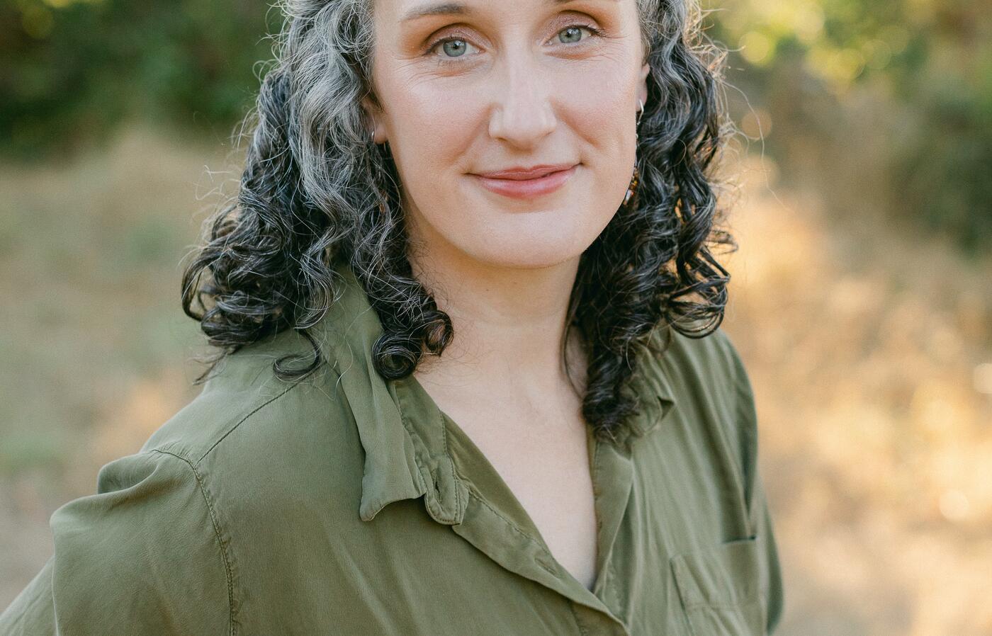 Headshot of Chelsea Mabie, a woman wearing a green dress outdoors