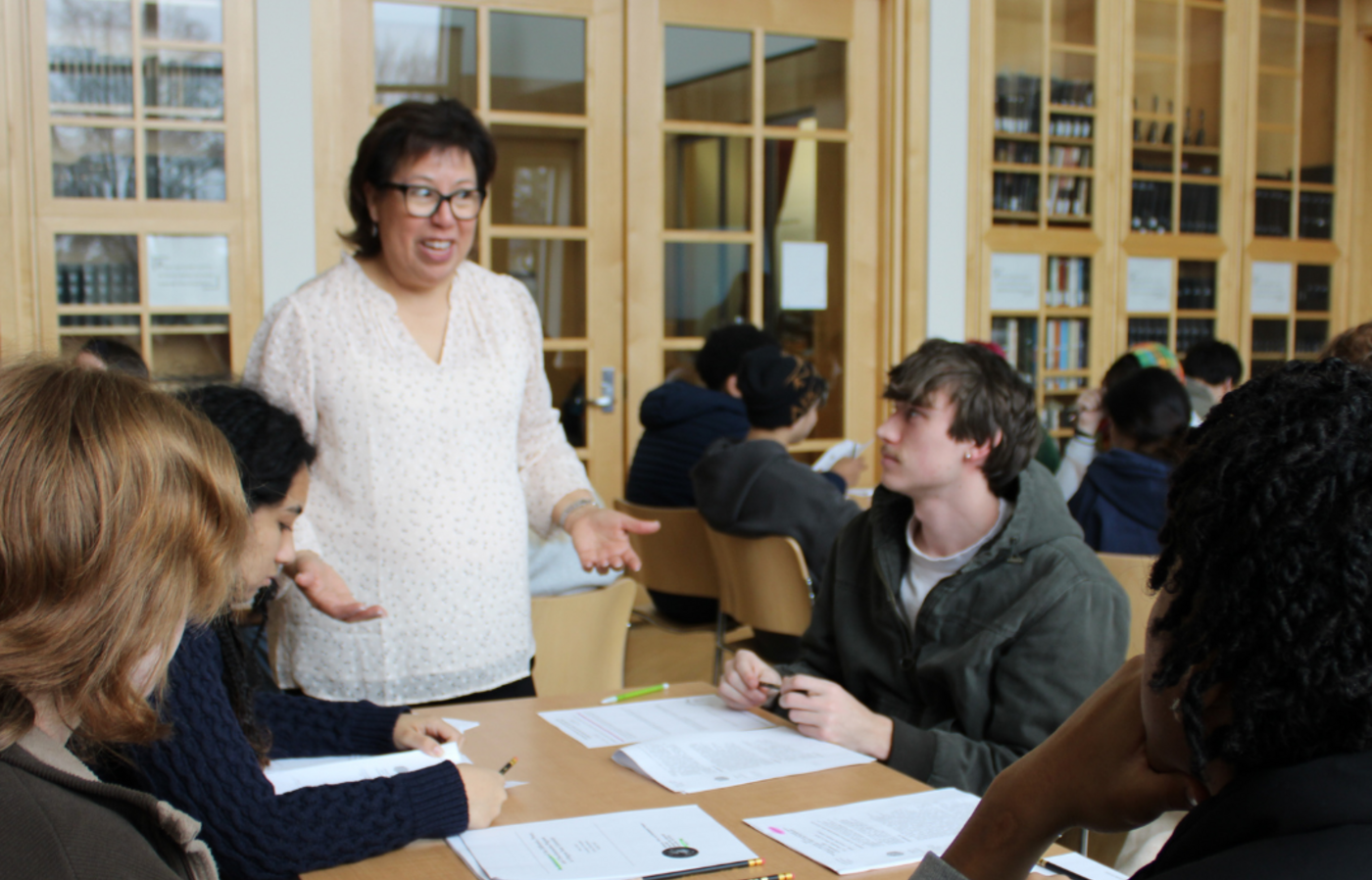 Instructor Ana Ramirez speaking to her students in the archives
