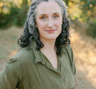Headshot of Chelsea Mabie, a woman wearing a green dress outdoors