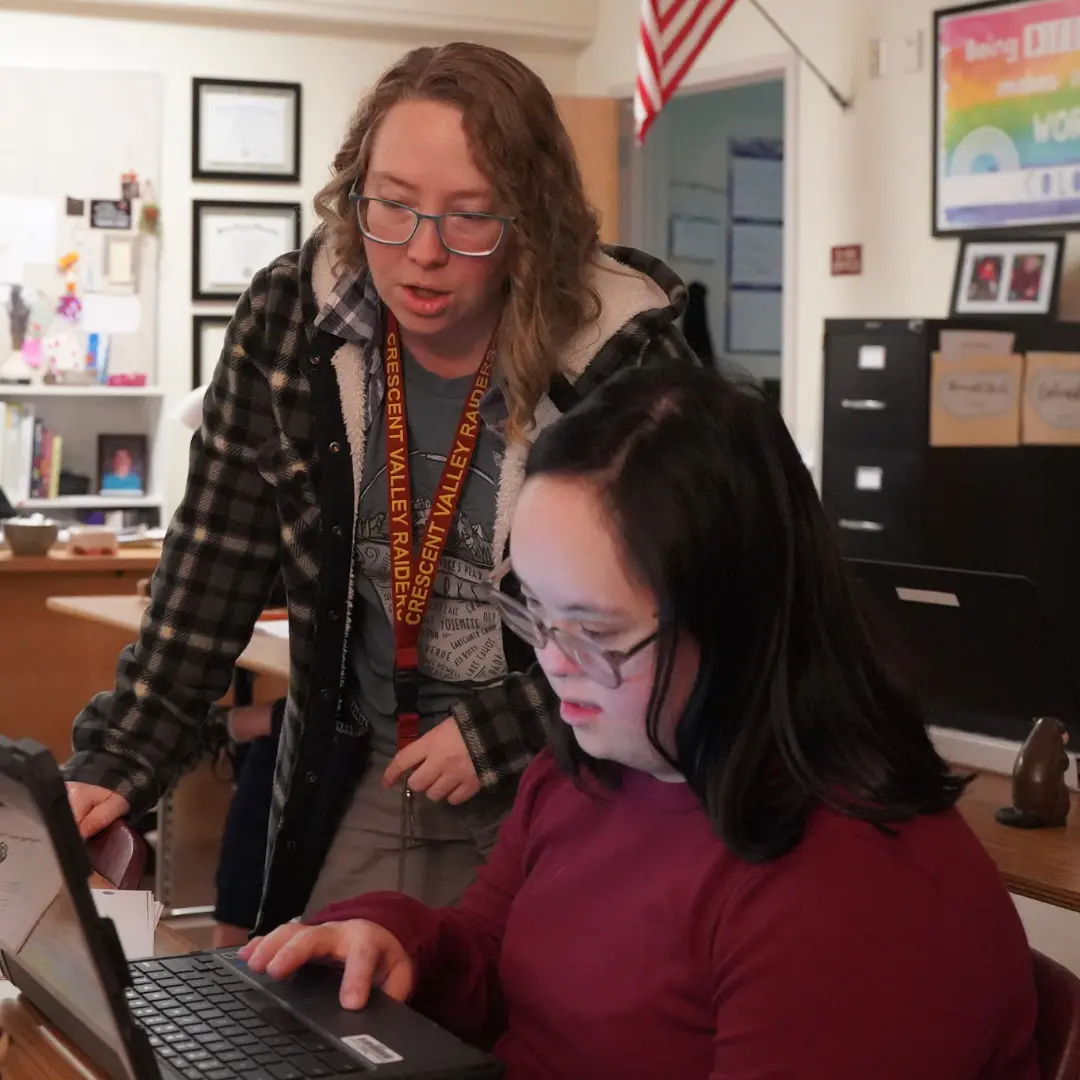 Special Education teacher helping a student on her laptop